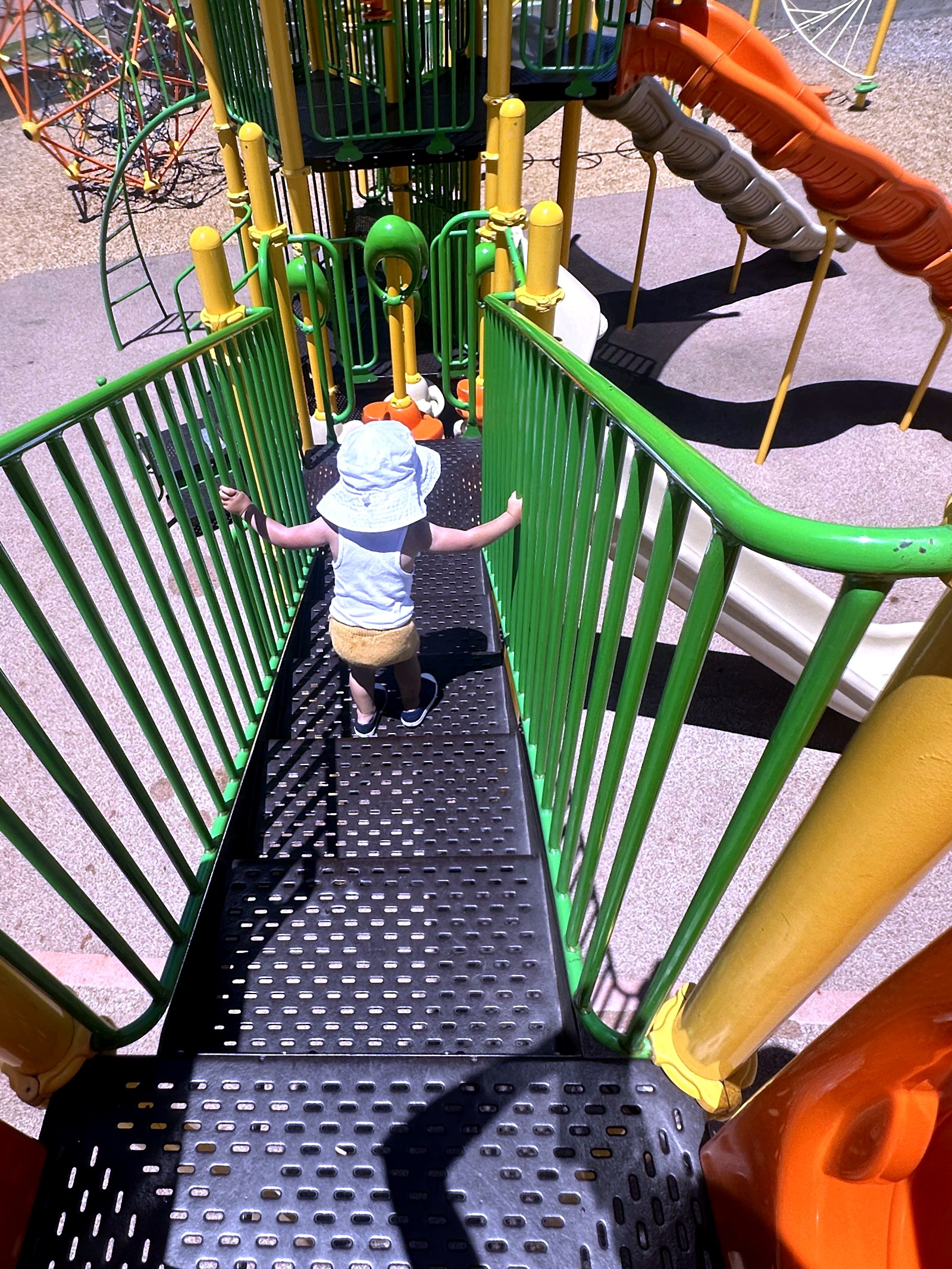 A toddler exploring the playground on a sunny day