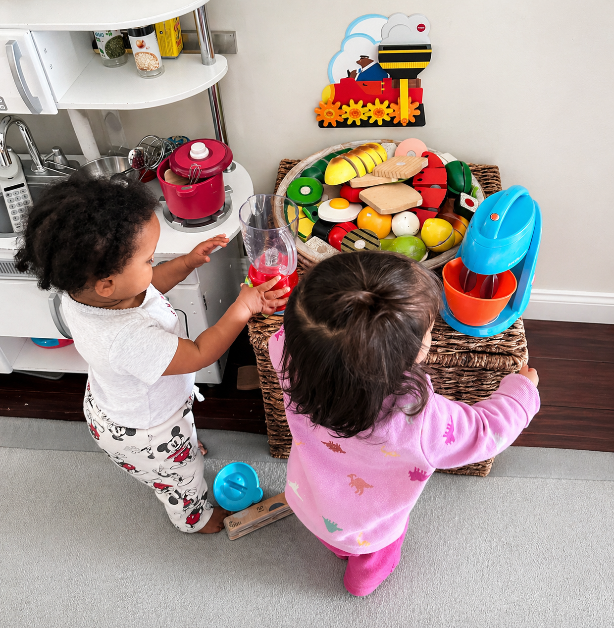 Two children cooking in the play kitchen with toy food